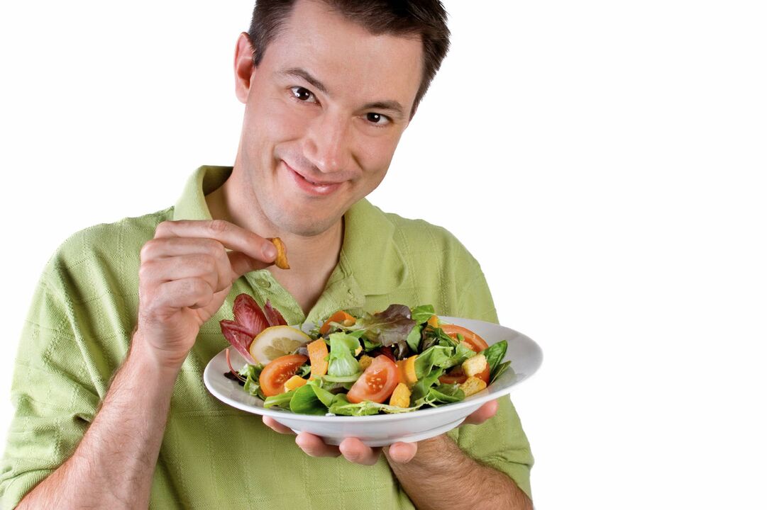 mand spiser grøntsagssalat for styrken